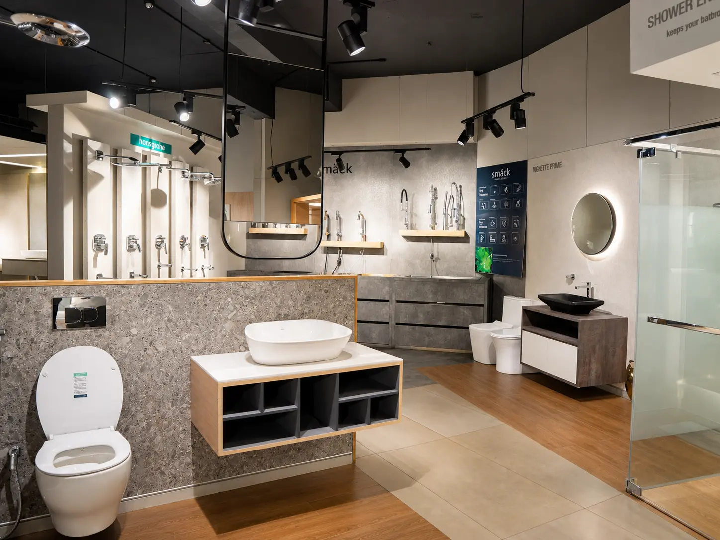 Bathroom display setting with vanity basin, wall fixtures, shower enclosure and mirrors.