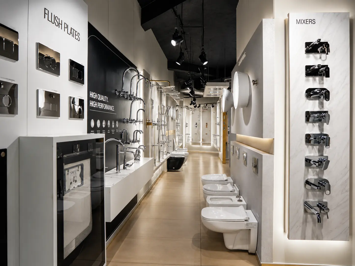 Faucet, mixer and flush plate displays in a sleek bathroom fixture corridor.