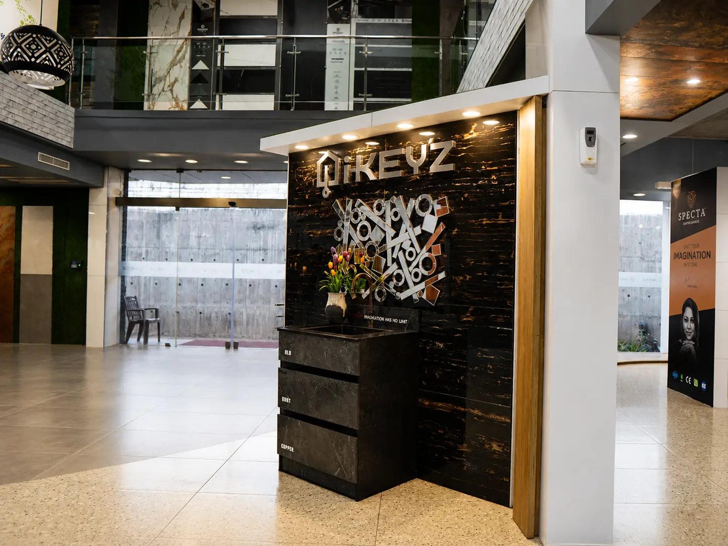 i-KEYZ feature display wall with black stone, gold veining and showroom floor beyond.